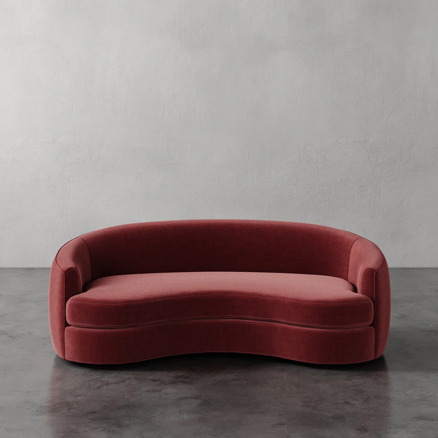 Lemieux et Cie Rulmann Sofa in terracotta, curved sofa with organic rounded form, shown on polished concrete floor against white plaster wall.