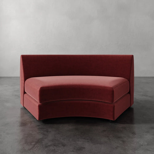 Lemieux Et Cie Rulmann Wedge Red curved sofa against a gray background