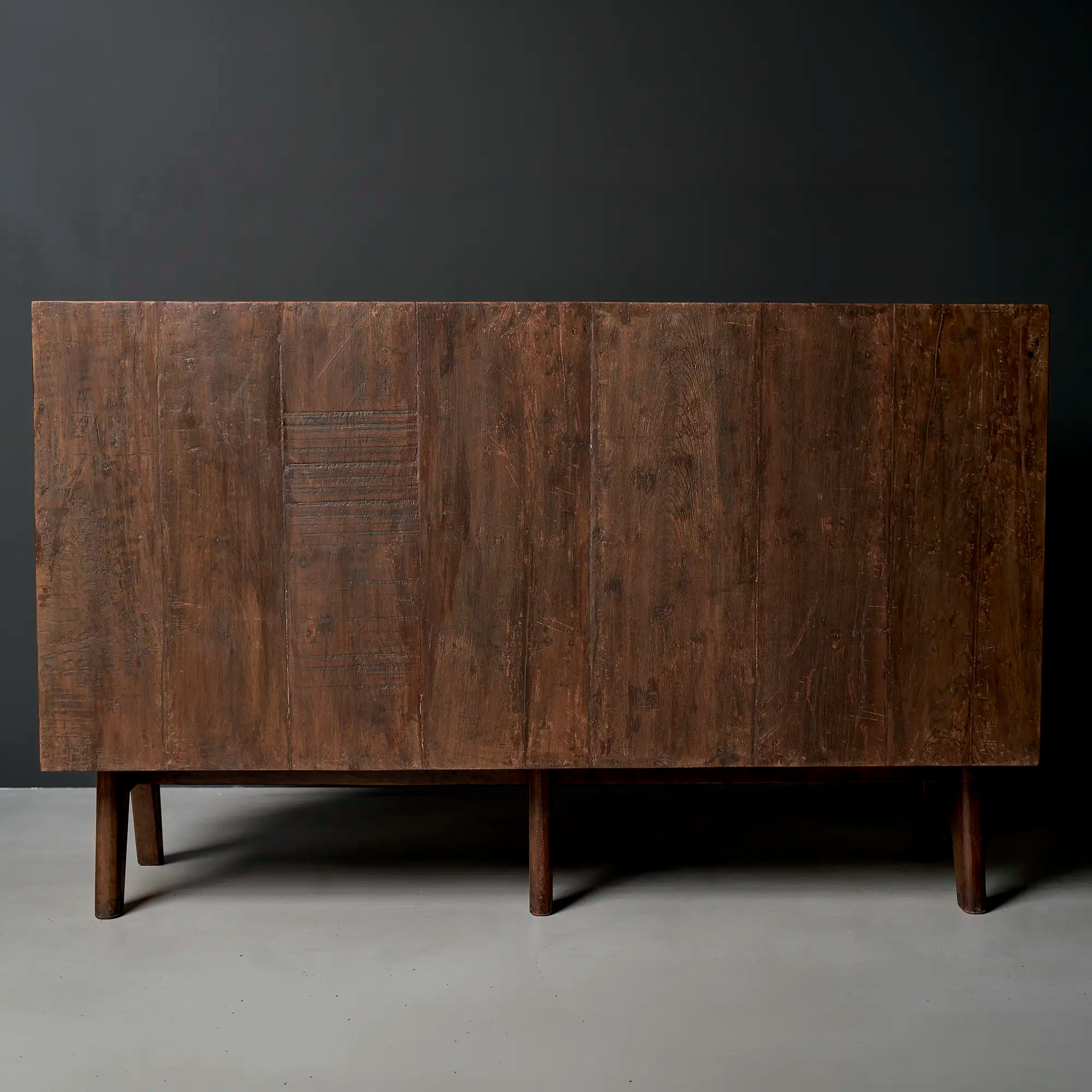 Lemieux et Cie Pierre Jeanneret teak four-door cabinet - rear studio view showing the plank back and the six tapered cylindrical legs, three front and three rear
