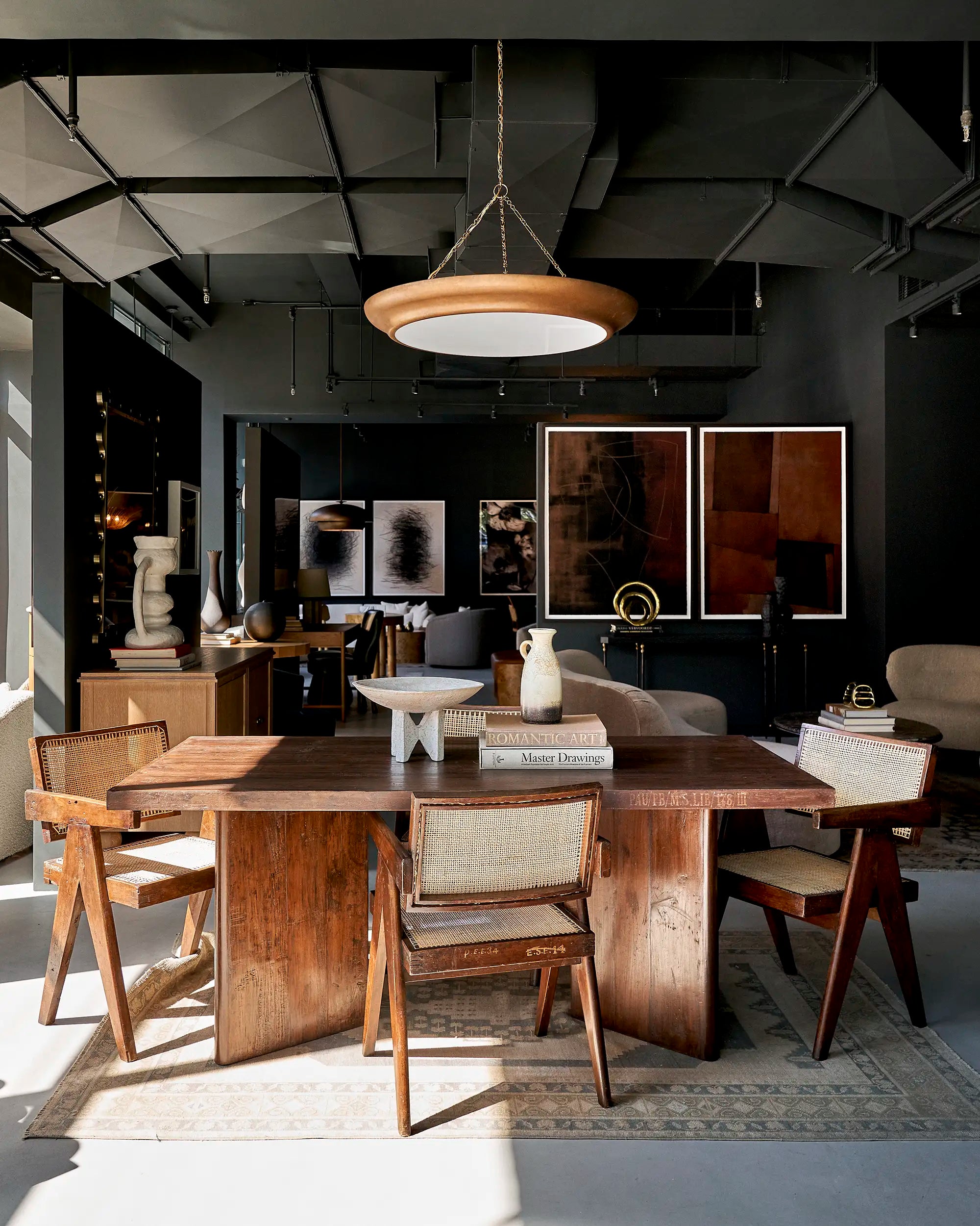 Lemieux et Cie Pierre Jeanneret library table in solid teak - in the showroom with surrounding chairs and pendant lighting