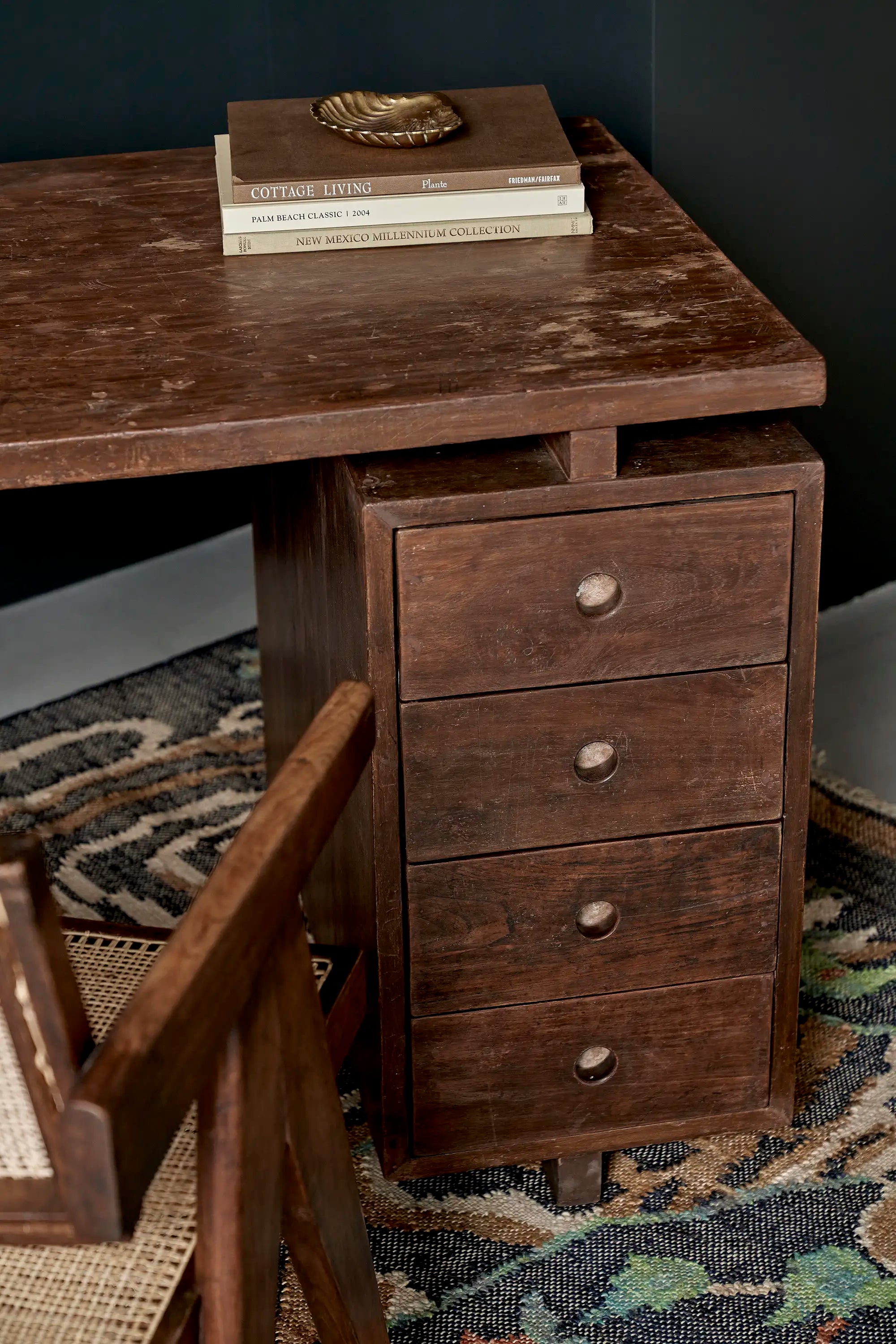 Lemieux et Cie Pierre Jeanneret writing desk in solid teak - styled three-quarter view showing the pedestal drawers with books on top