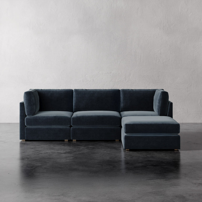 Lemieux Et Cie Chanaux 4-Pc Sectional Gray sectional sofa on a concrete floor with a plain white wall background