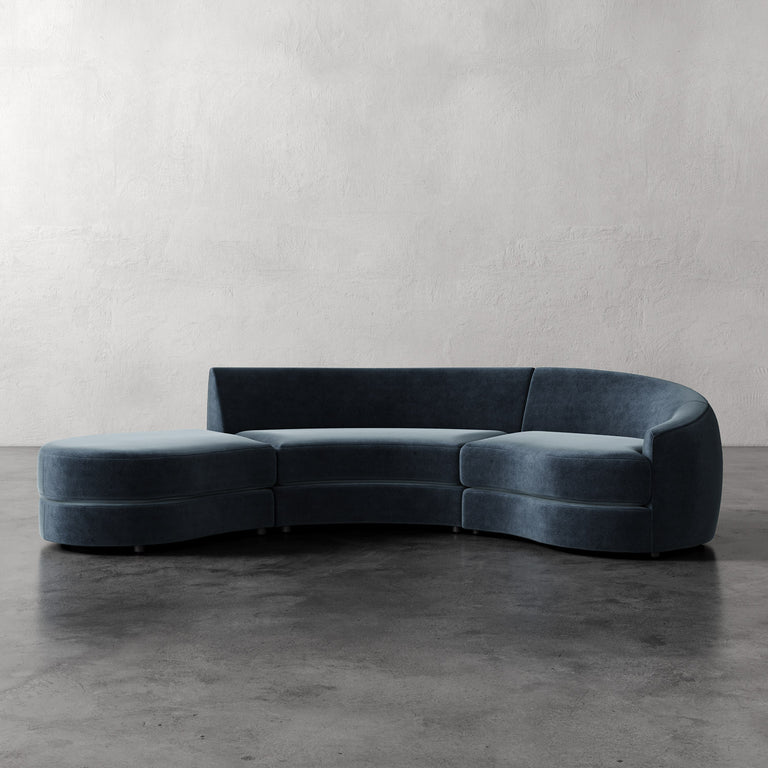 Lemieux Et Cie Rulmann 3-Piece Right Sectional Blue velvet sectional sofa on a gray floor with a plain wall background