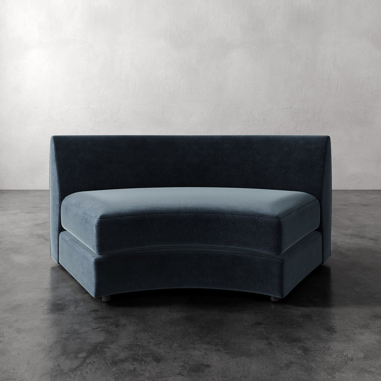 Lemieux Et Cie Rulmann Wedge Blue velvet sofa against a plain wall