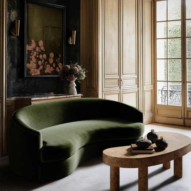 Lemieux Et Cie Rulmann Sofa Rulmann brennecoffee vignefleurie plivotsconce etiennevase cailloupots Modern living room with a green sofa, wooden coffee table, and large window.