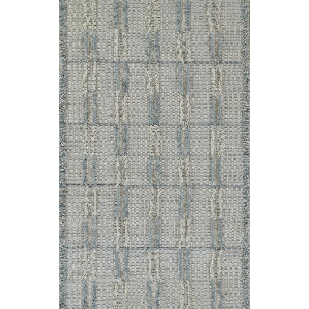 Lemieux et Cie Cluny hand-woven wool rug in soft ivory and blue, tribal-inspired pattern with leather accents and fringe, shown on white backdrop.
