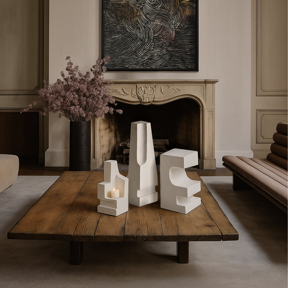 Lemieux et Cie La Structure Sculptures in white, geometric sculptural forms on wood coffee table, styled in sitting room with carved stone mantel and neutral walls.