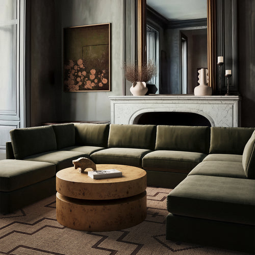 Lemieux Et Cie Chanaux 8-Pc SectionalSQchanaux-tugart-avenircoffee-vignefleurie-anouarvases-achille-bison Modern living room with a green sectional sofa, round wooden coffee table, and decorative elements.