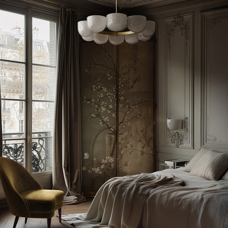 Lemieux et Cie Cheverny Large Chandelier with white milk glass shades and burnished brass detailing, suspended over a bed with Cheverny Small Sconce on the wall.