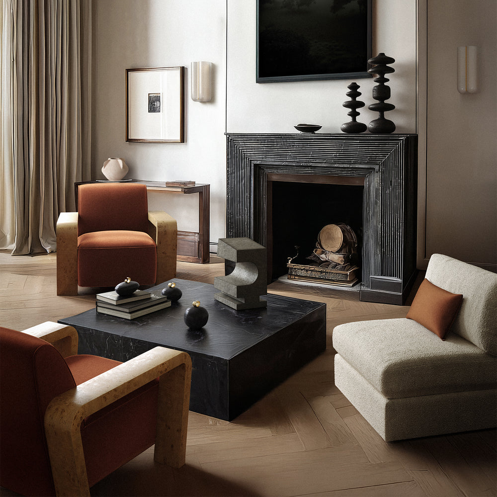 Lemieux et Cie Dumas Lounge Chair in warm rust and neutral tones, low-profile armchair styled in a living room with wood floors and fireplace.
