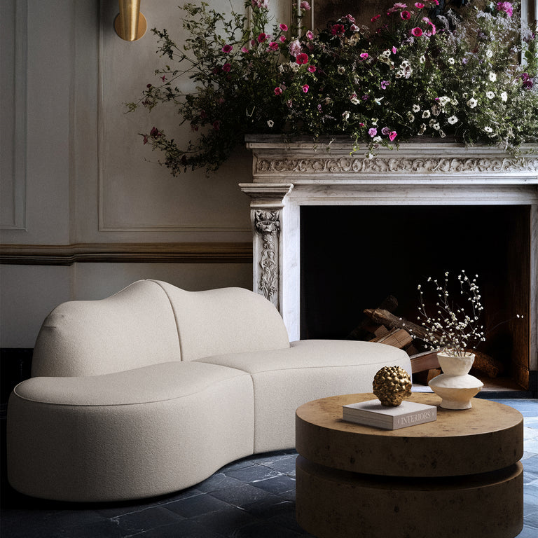 Lemieux Et Cie serpentine 2-Piece Sectional Modern beige sofa in a stylish living room with a fireplace and decorative elements.