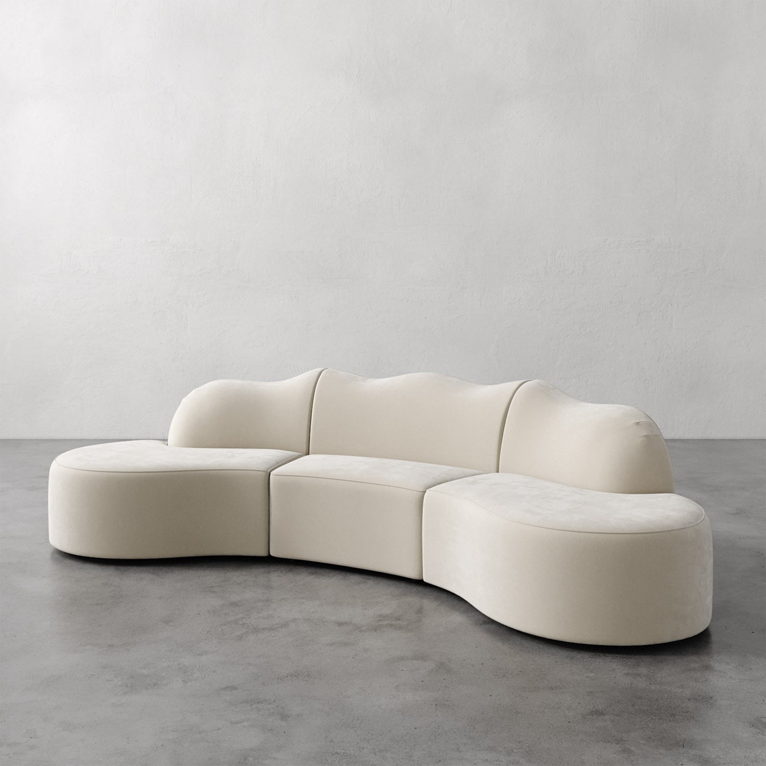 Lemieux et Cie Serpentine Sectional Sofa in ivory upholstery, modular curved three-piece sofa on polished concrete floor against textured plaster walls.