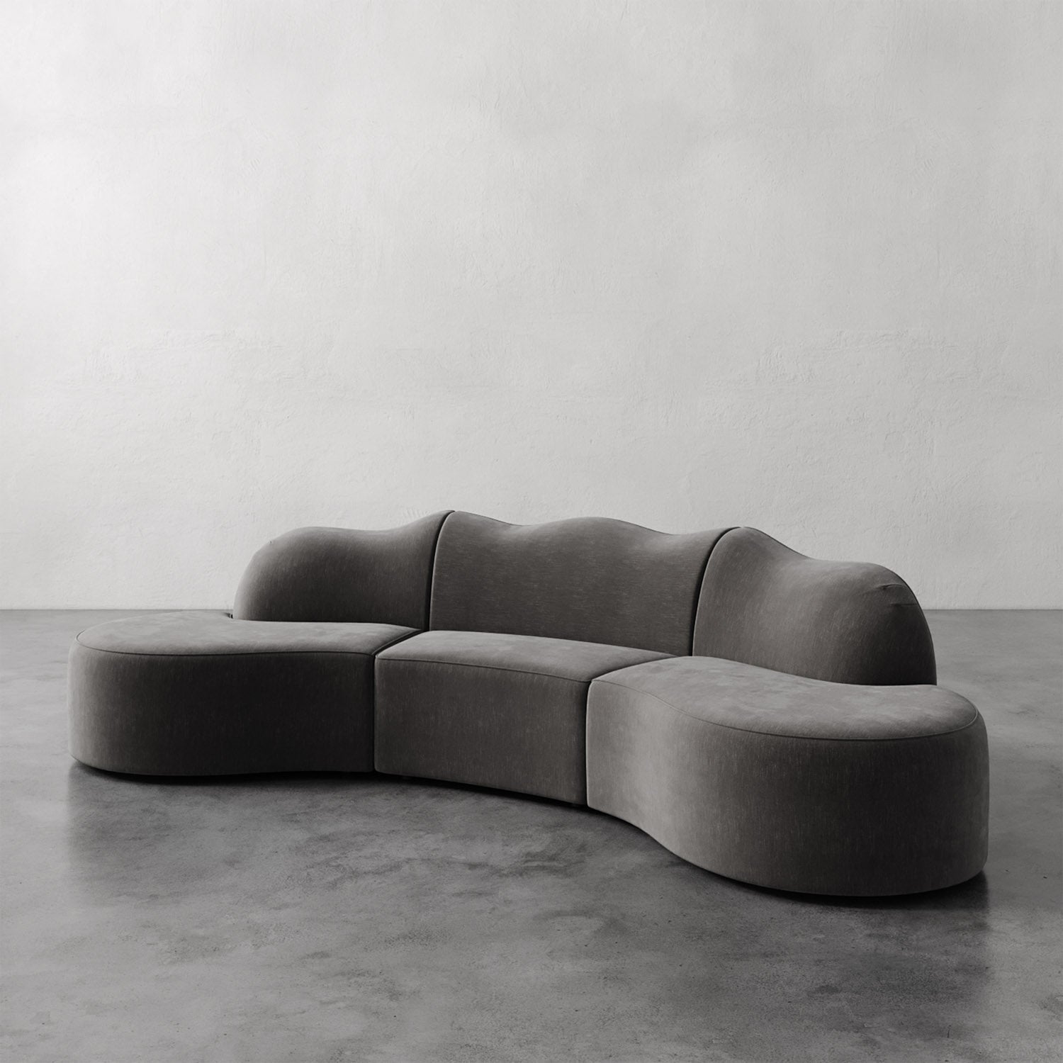 Lemieux et Cie Serpentine Sectional Sofa, sculptural modular seating with organic rounded forms, shown on polished concrete floor against white plaster wall.