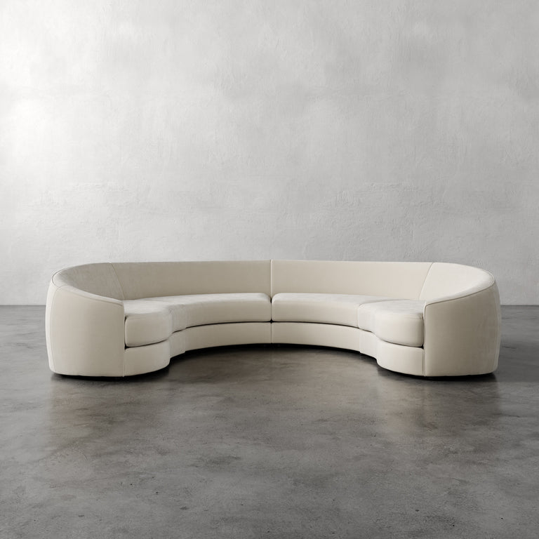 Lemieux Et Cie Rulmann 4-Piece Sectional Curved beige sofa against a plain gray wall