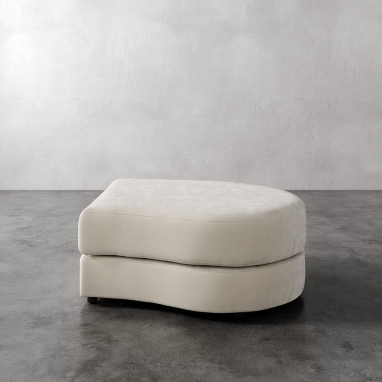 Lemieux Et Cie Rulmann Right Ottoman Beige ottoman on a gray floor with a white wall background