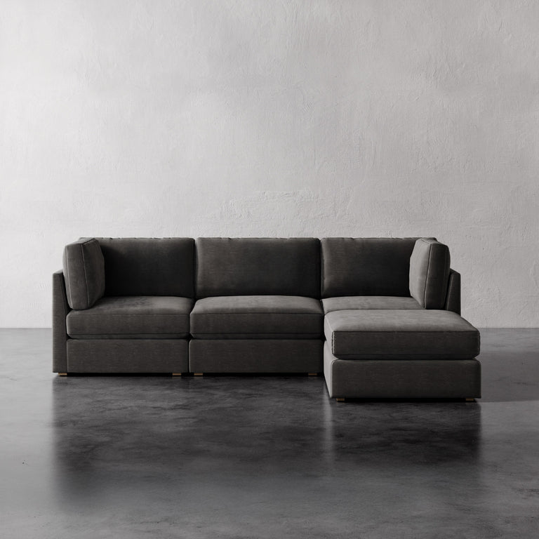 Lemieux Et Cie Chanaux 4-Pc Sectional Gray sectional sofa on a concrete floor with a white wall background