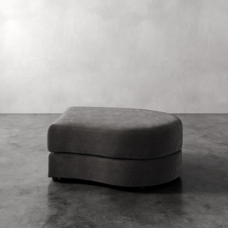 Lemieux Et Cie Rulmann Right Ottoman Gray ottoman on a concrete floor with a plain white wall background