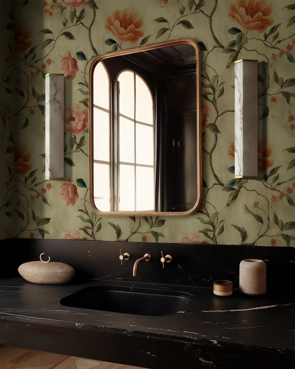 Bathroom with Trellis Bloom floral wallpaper, black countertop, and an arched mirror, featuring the Lemieux et Cie Cleor sconce, a tall rectangular designer lighting fixture with Art Deco influence, mid-century modern sensibility, and a refined faux alabaster panel.