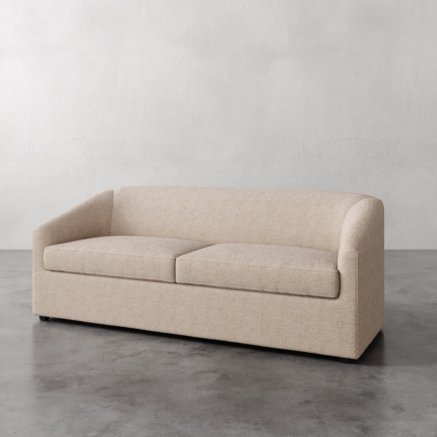 Lemieux et Cie Arvelle Queen Sleeper in warm neutral upholstery, low-profile sofa with rounded arms, shown on polished concrete floor against white walls.