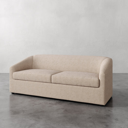 Lemieux et Cie Arvelle Queen Sleeper in warm neutral upholstery, low-profile sofa with rounded arms, shown on polished concrete floor against white walls.