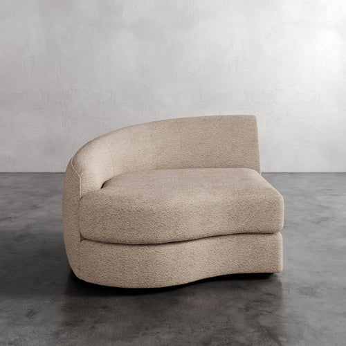Lemieux Et Cie Rulmann Left Arm Chair Beige sofa on a gray floor with a plain wall background