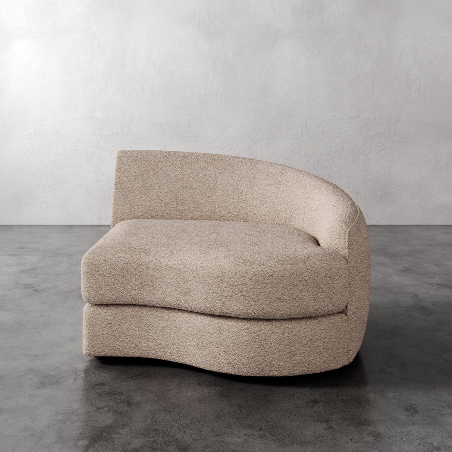 Lemieux Et Cie Rulmann Right Arm Chair Beige curved sofa on a gray floor with a plain wall background