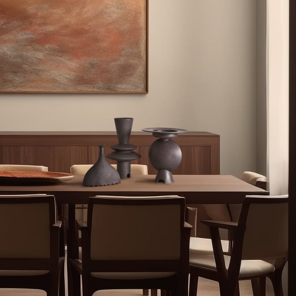 Lemieux et Cie Adelyn Geometric Vase in black, sculptural vessel with stacked spheres and conical forms, displayed on wood dining table with abstract artwork and neutral walls.
