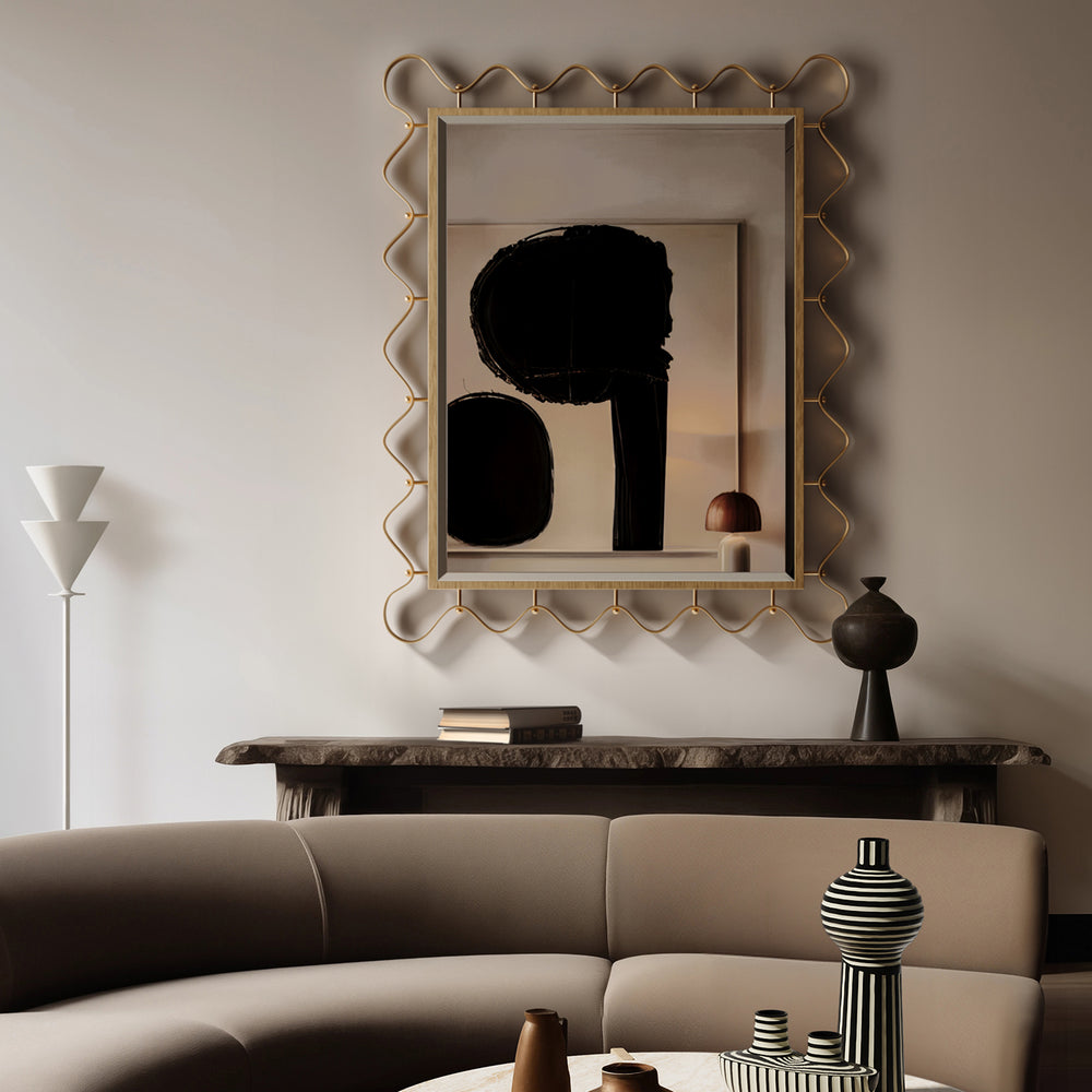 Lemieux et Cie brass mirror with sculptural scalloped frame in antique finish, hung above a marble console in a neutral sitting room with abstract art.