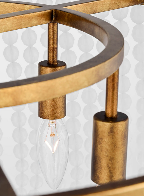 Lemieux et Cie Bellecour Chandelier detail in vintage gilded brass with honed crystal beads, close view of sculptural frame against patterned wallpaper backdrop.