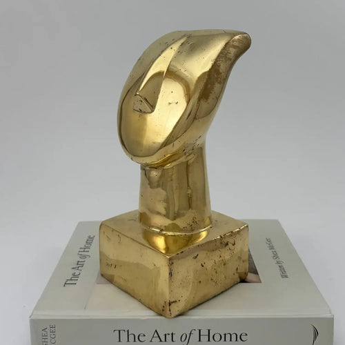 Lemieux et Cie Vintage Art Deco Abstract Brass Bust Sculpture, sculptural form with warm patina, displayed on book stack against neutral backdrop.