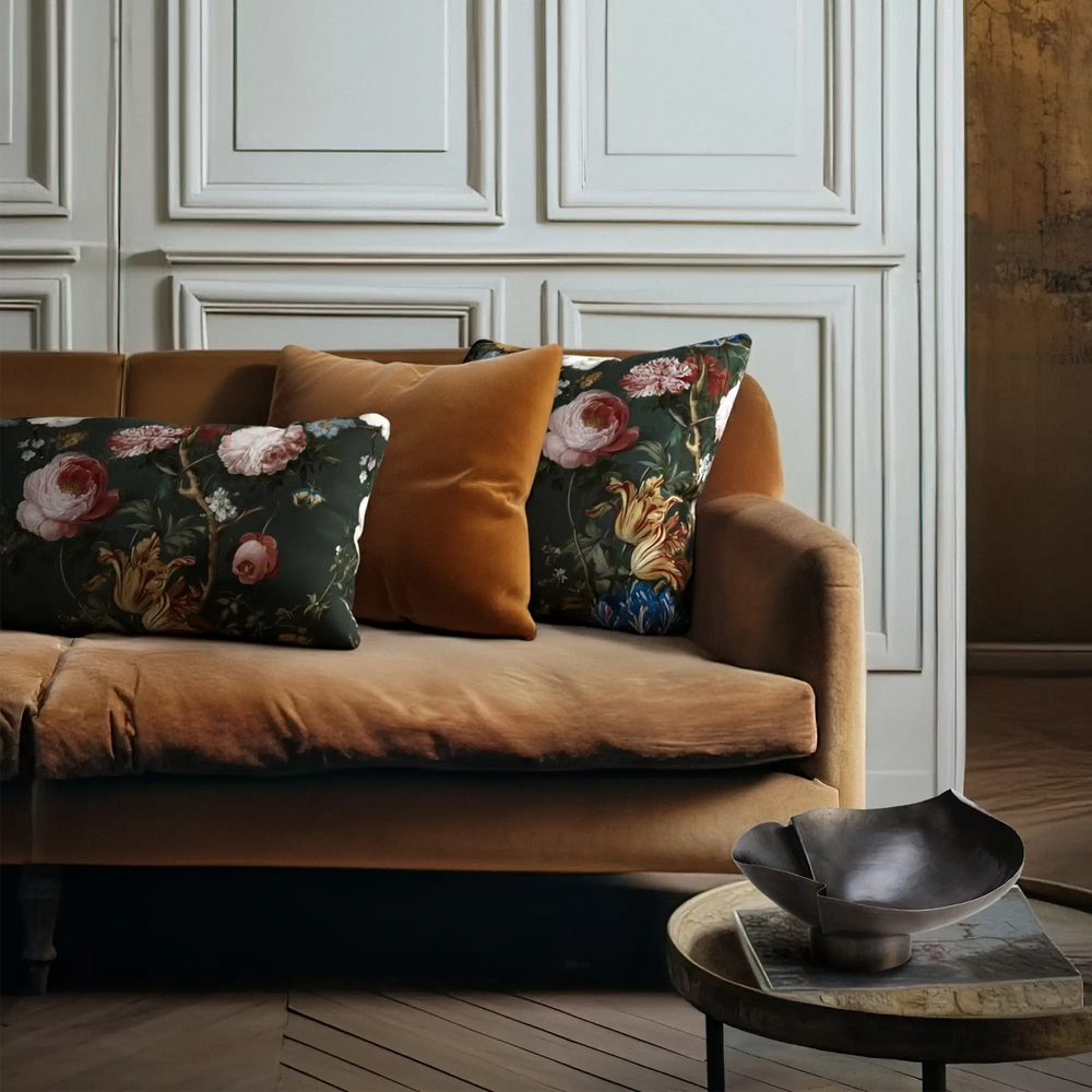 Lemieux et Cie Dutch Rose Velvet Pillow in dark floral print and warm amber velvet, decorative pillows on sofa in white-paneled sitting room with wood floors.