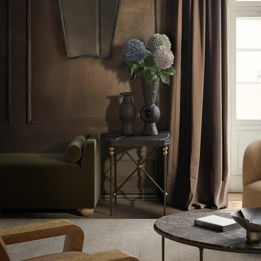Lemieux et Cie Cambert Square Side Table with honed Nero Marquina marble top and bronze iron frame with brass accents, styled in sitting room with wood-paneled walls and layered textiles.
