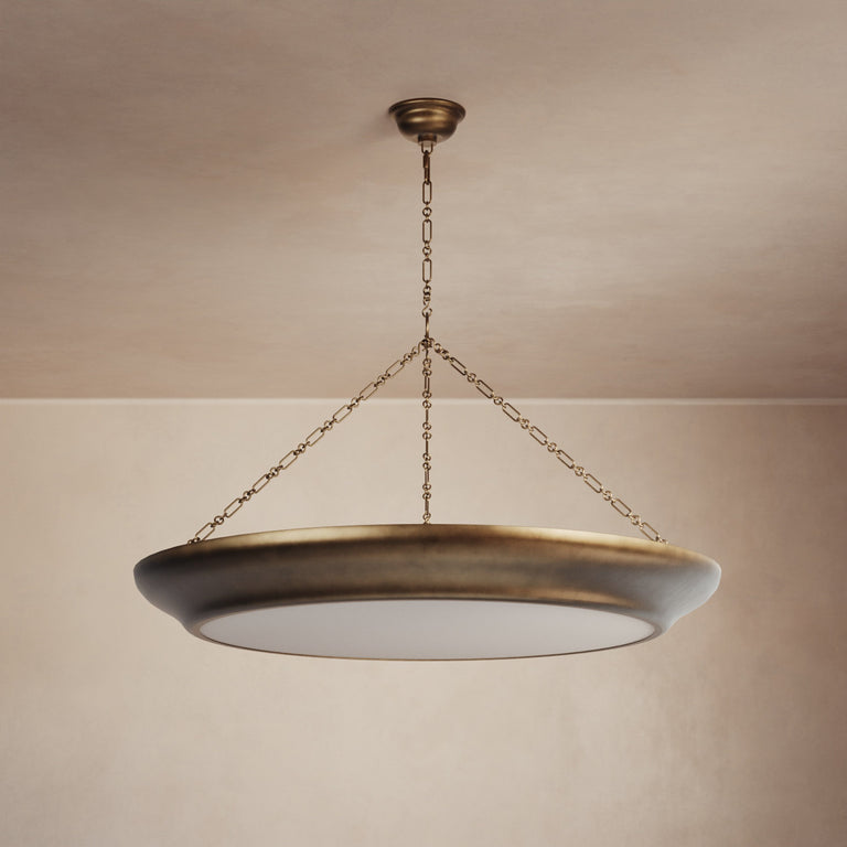 Lemieux et Cie Lenoir Chandelier, sculptural iron bowl form in matte finish suspended by handmade chain, hung in a neutral plaster-walled room.