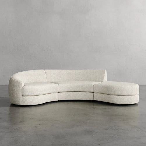 Modern Curved beige sofa against a plain gray wall Rulmann 3-Piece Left Sectional Chunky Natural