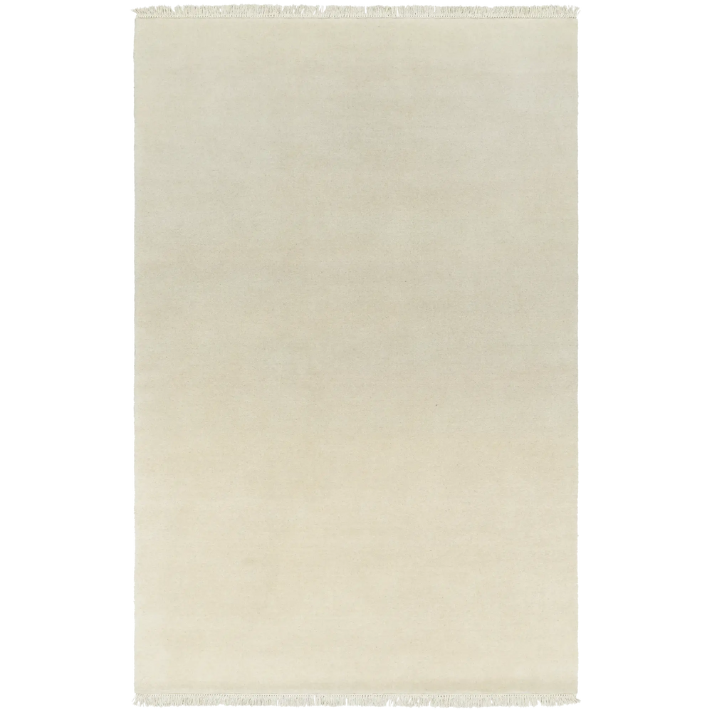 Lemieux et Cie Plume Handmade Wool Rug in natural ivory, solid wool rug with fringe detail, shown on white studio backdrop.