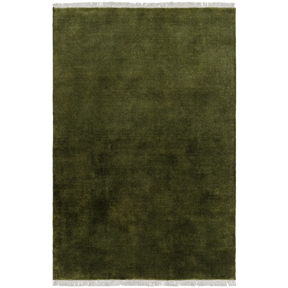 Lemieux et Cie Plume Handmade Wool Rug in moss green, textured solid with fringe detail, shown on white studio backdrop.