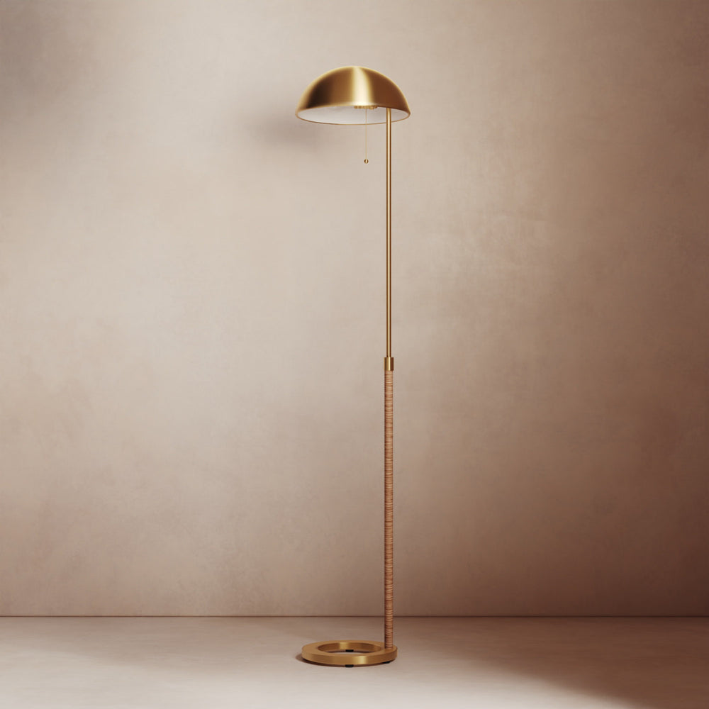 Lemieux et Cie Balleroy Floor Lamp in brass with dome shade and rattan-wrapped stem, floor lamp shown against neutral plaster wall.