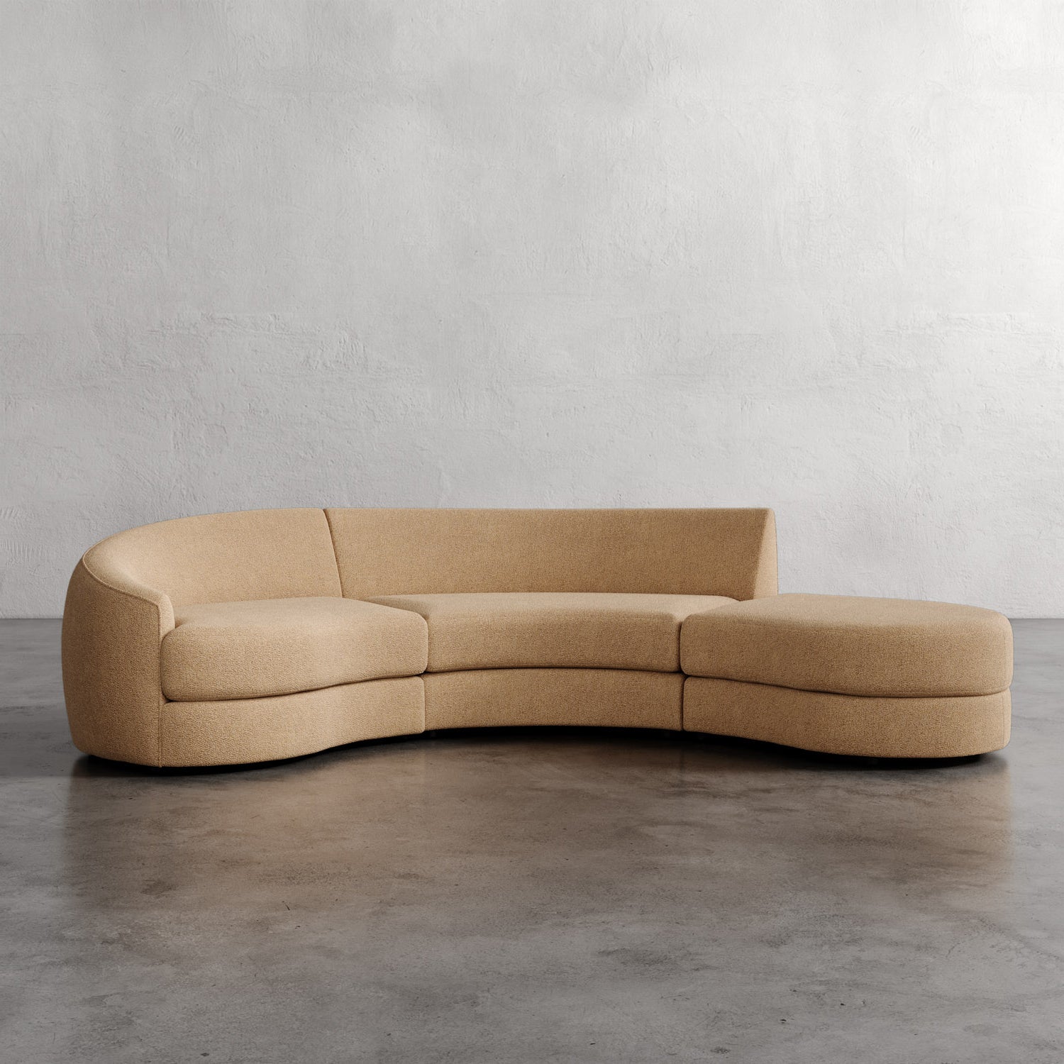 Beige curved sofa on a gray floor with a plain wall background_ Rulmann 3-Piece Left Sectional Golden Rod