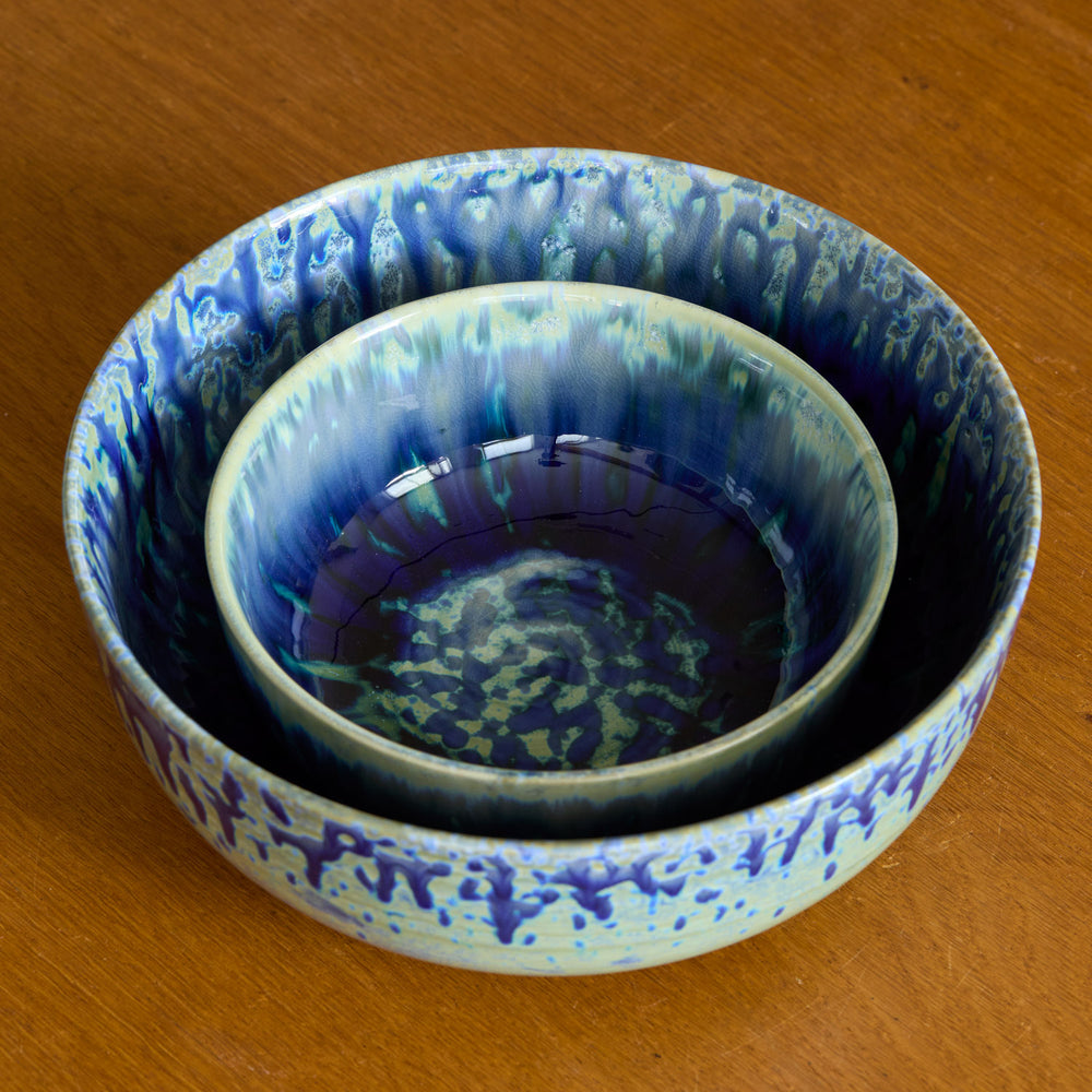 Lemieux et Cie Hanami Stoneware bowls in indigo reactive glaze, two nested ceramic bowls with atmospheric gradients, resting on warm wood surface.