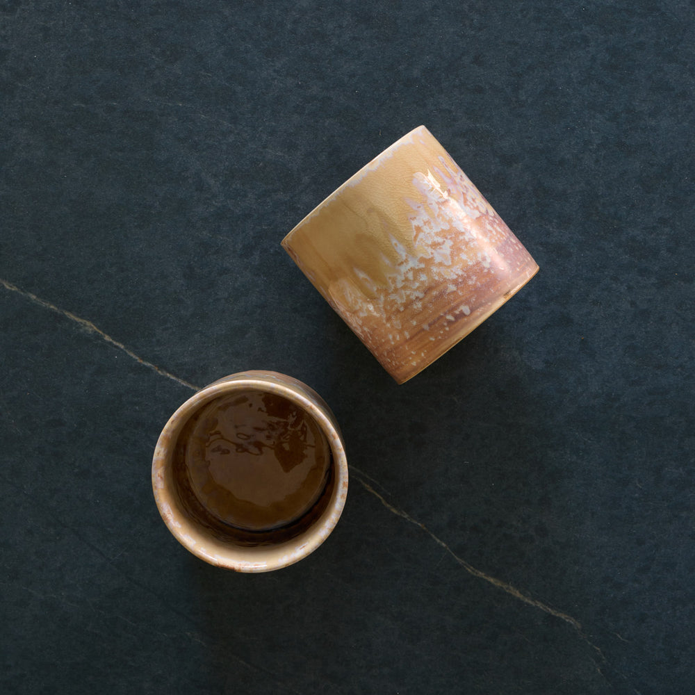 Lemieux et Cie Hanami Stoneware Mug Set in Sand, ceramic mugs with reactive glaze showing warm tonal gradients, shown on dark stone surface.