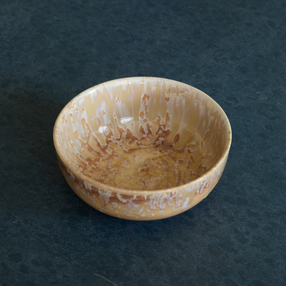 Lemieux et Cie Hanami Stoneware Bowl in sand with reactive glaze, rounded ceramic bowl shown on dark stone surface.