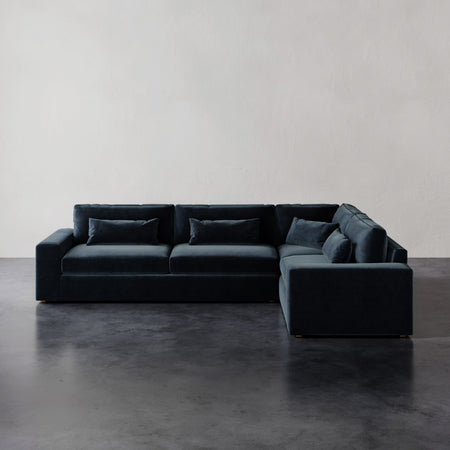 Lemieux et Cie Lacroix Left Arm Sectional in dark upholstery, modular sofa with bolster pillows, shown on polished concrete floor against neutral walls.