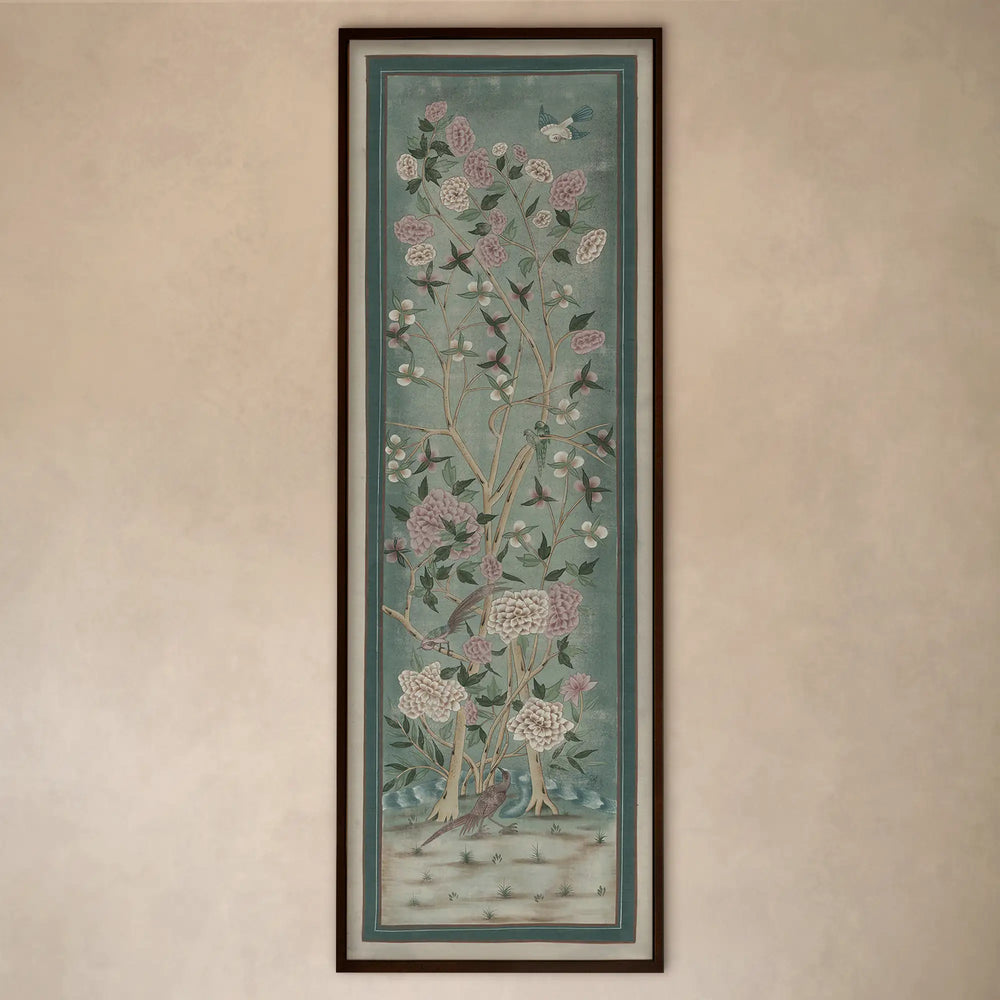Lemieux et Cie Jardin de Jaipur art panel, vertical framed print depicting flowering branches and birds in soft blue-green tones, hung on warm neutral wall.