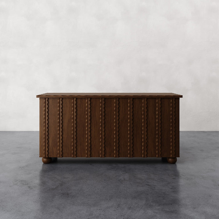 Lemieux et Cie Marchand 4-Door Cabinet with vertical inlay detailing and turned feet, low cabinet shown on stone floor against white walls.