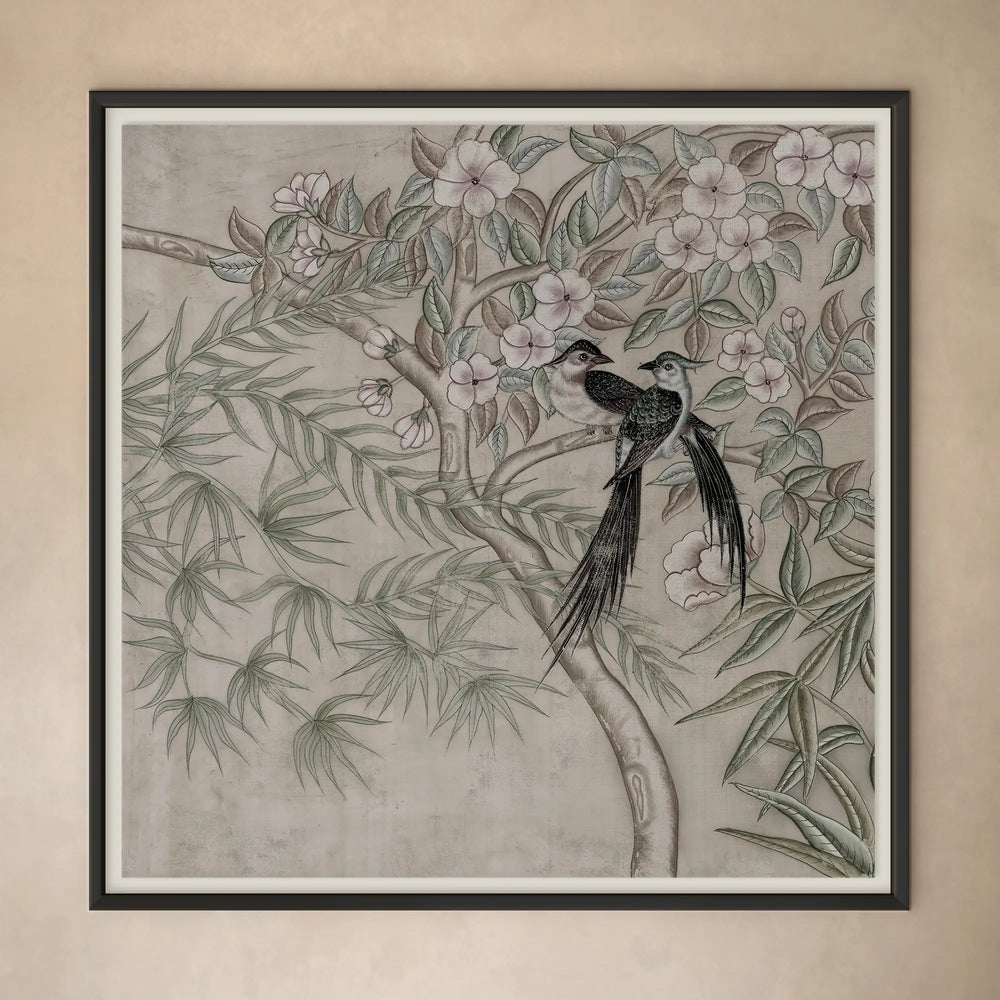 Lemieux et Cie framed artwork depicting two birds on flowering branches in muted tones, shown against a neutral plaster wall in soft light.
