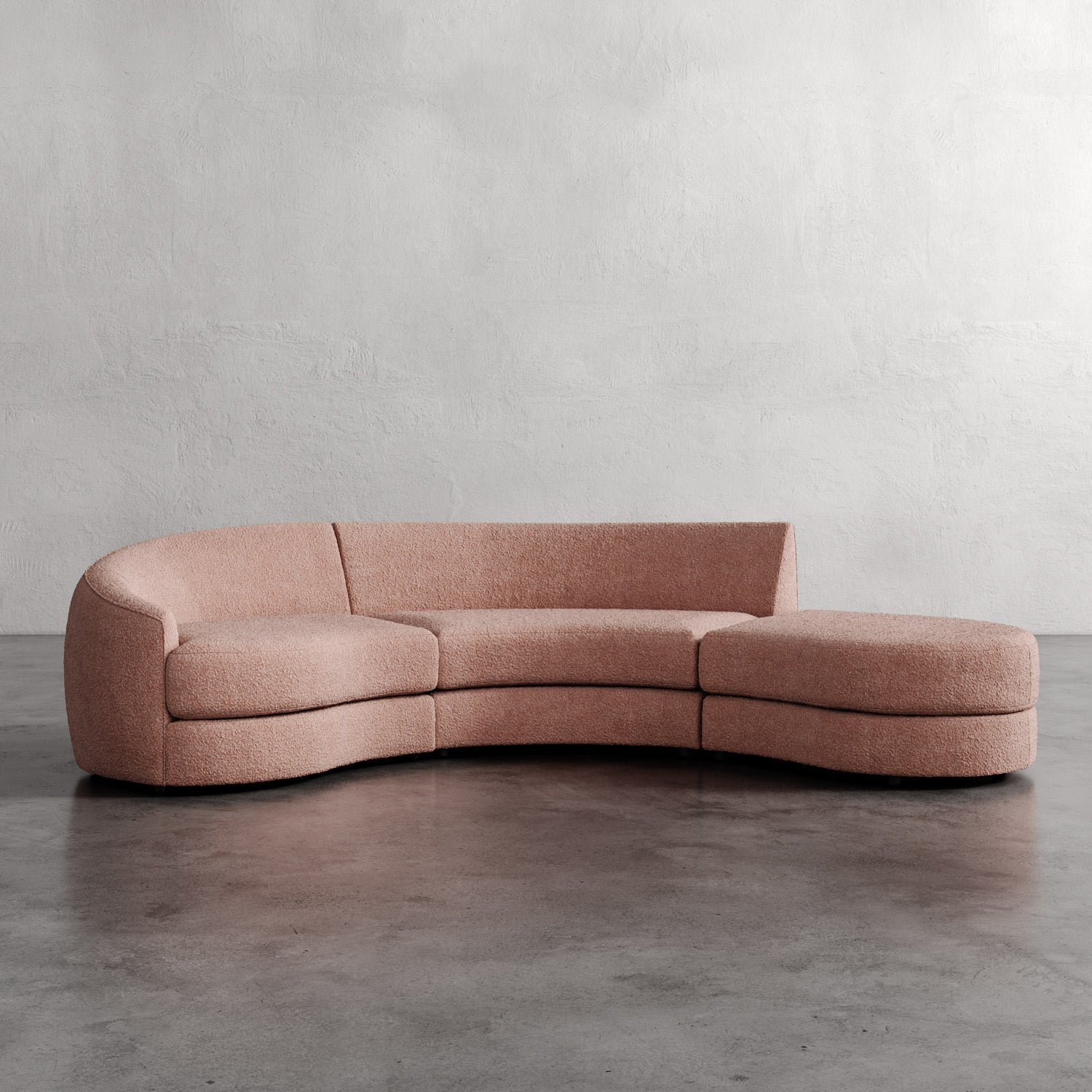 Pink curved sofa on a gray floor with a plain wall background. Rulmann 3-Piece Left Sectional Rosewood Berber