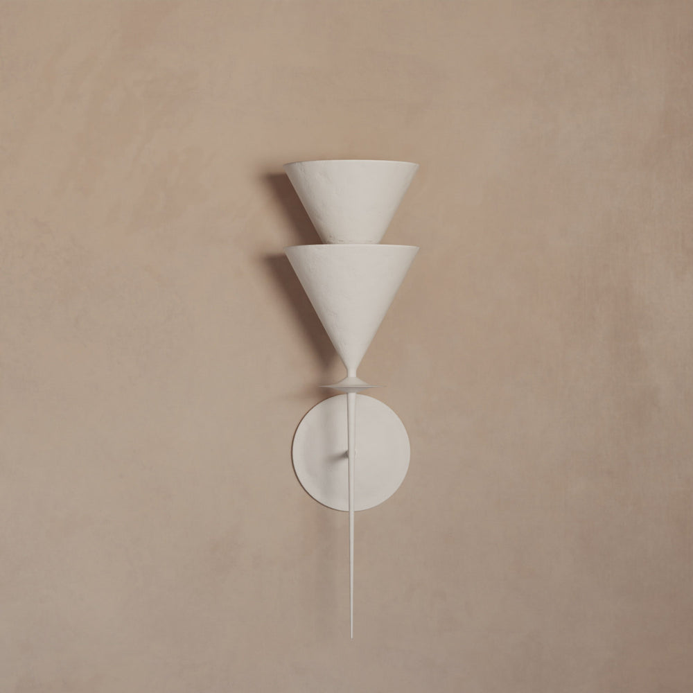 Lemieux et Cie Gurara Chevrette sconce in white plaster, geometric wall light with conical shades and circular backplate, mounted on warm neutral wall.