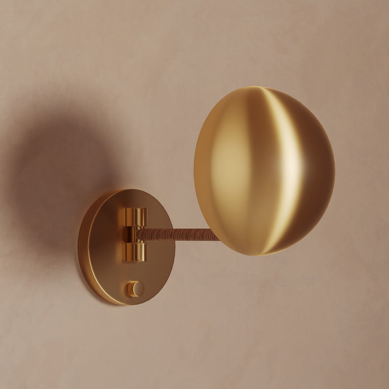 Lemieux et Cie Chambord Sconce in warm brass, sculptural wall light with organic spherical shade and circular backplate on neutral plaster wall.