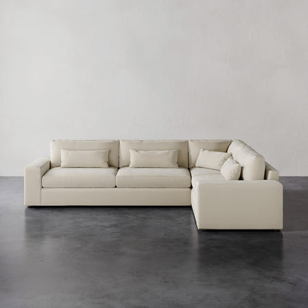 Lemieux et Cie Lacroix Left Arm Sectional in ivory, modular sofa with clean rectilinear form, shown on dark concrete floor against neutral walls.
