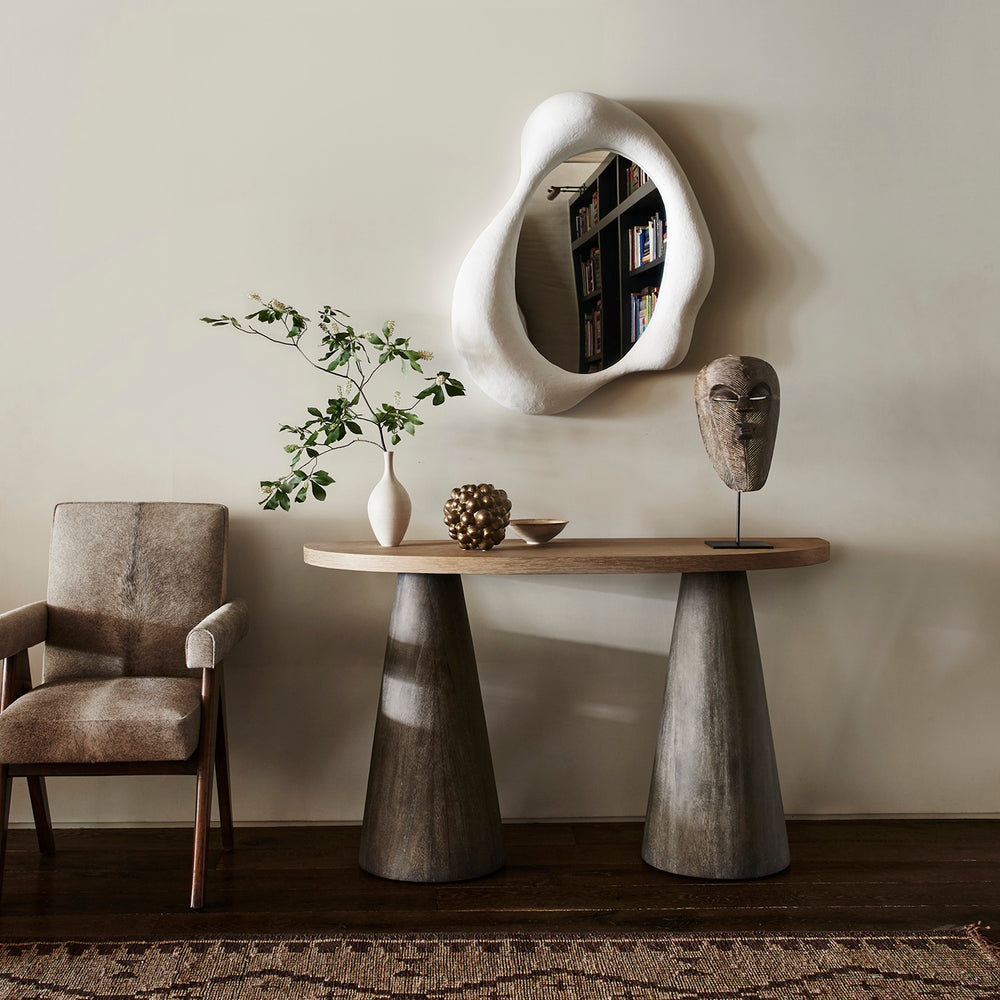 Lemieux et Cie sculptural hurricane, organic rounded form in white, styled on console with neutral walls, mid-century chair, and warm ambient light.
